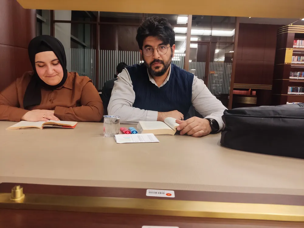 Adem Külük, öğrencisiyle kütüphanede matematik çalışırken